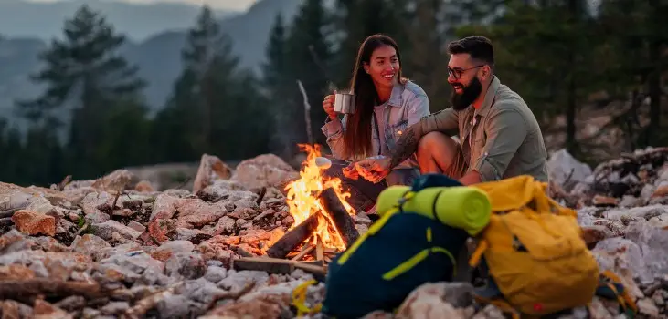happy couple enjoying coffee at camp